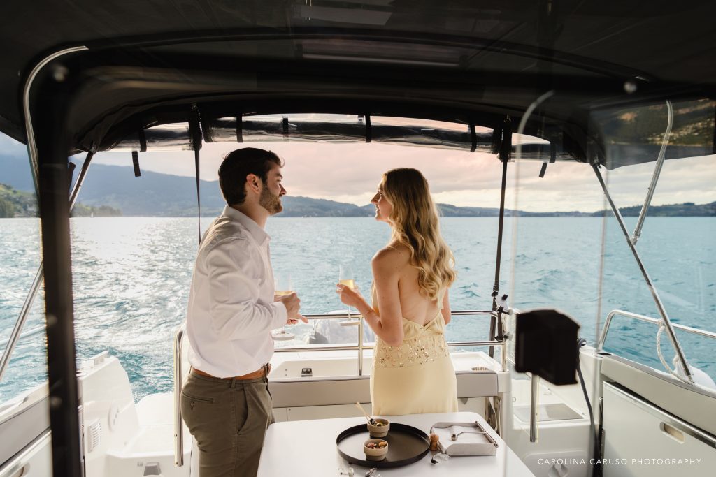 Couple celebrating a romantic marriage proposal aboard a private boat on Lake Lucerne